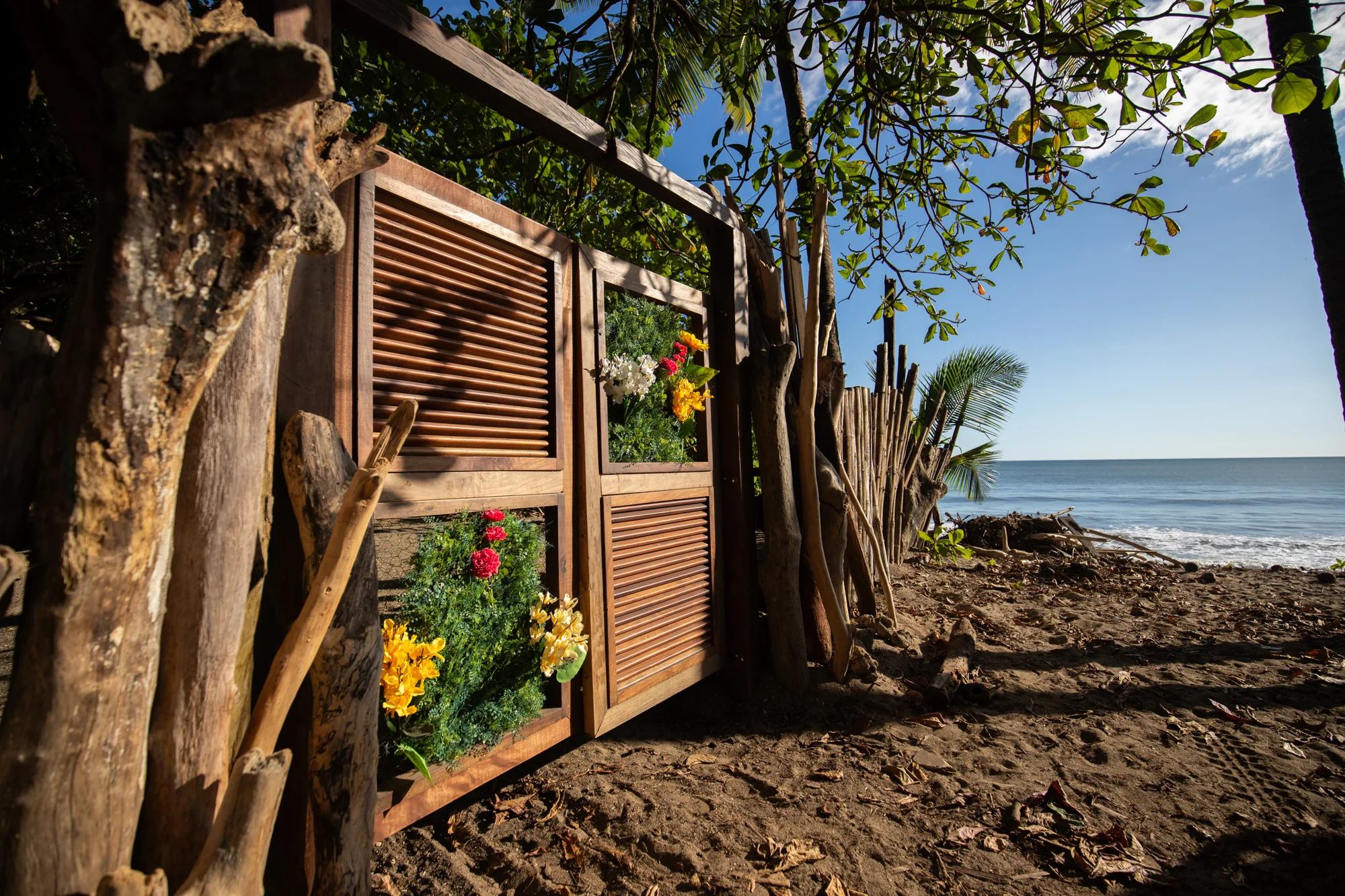 Flower-decorated wooden gate beside the Pacific shoreline